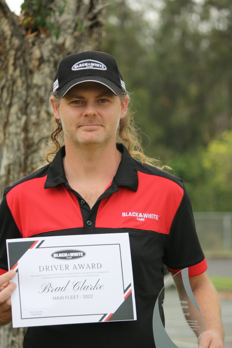 Black & White Cabs' Maxi Taxi Driver of the Year posing with his plaque