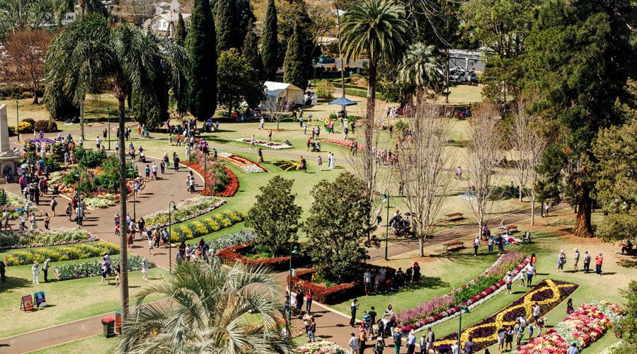 Birds-eye-view of Queens Park in Toowoomba. There are people walking through the park, and there is lots of greenery around.